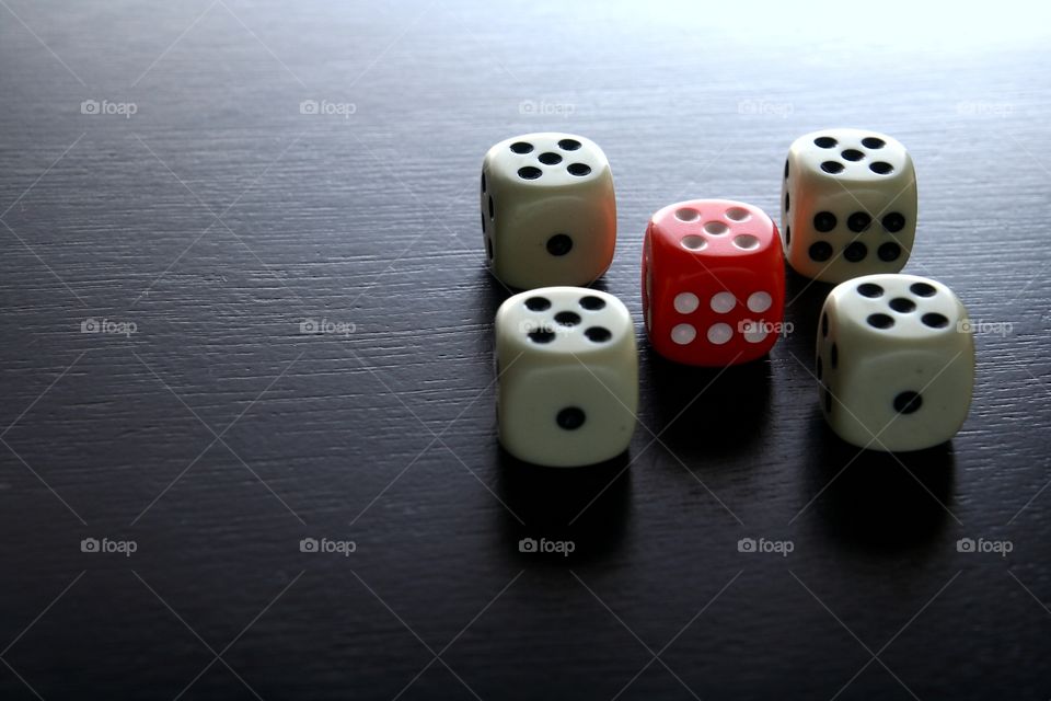 red and white game dice. 1 red game dice  among 4 white game dice