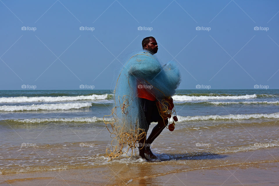 fisherman with fishing net in a beach