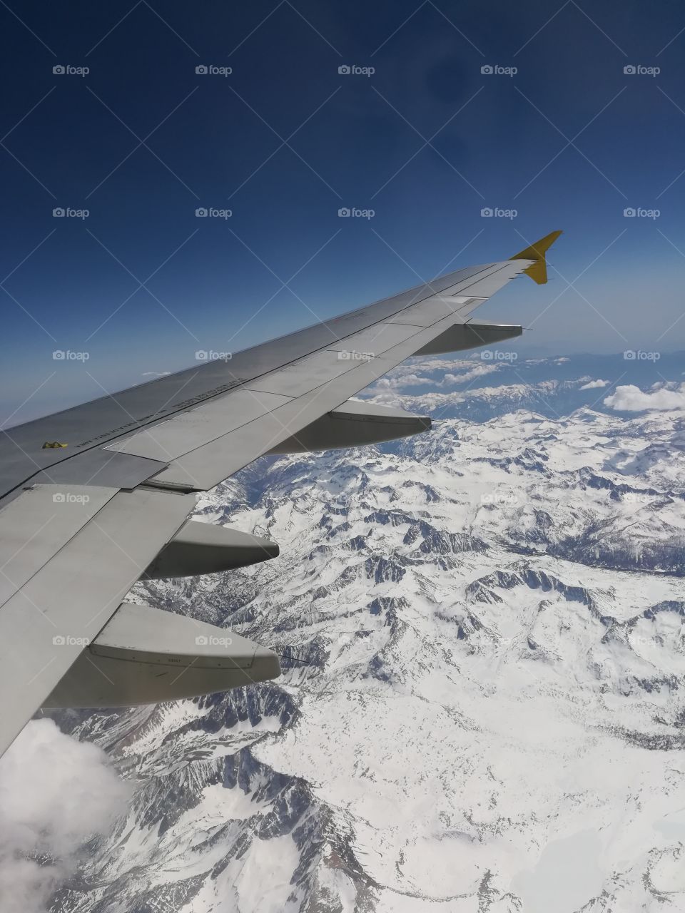 airplane wing over a snow covered mountain range