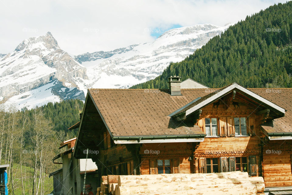 lovely swiss chalet with mountains in background .