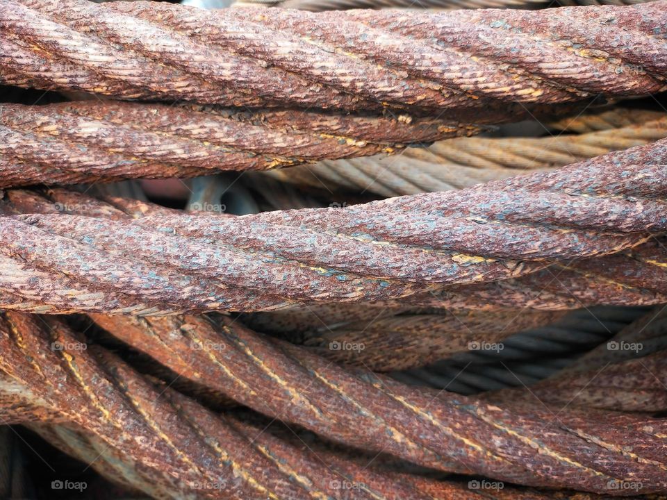 Selective focus of a pile of rusty wire slings.