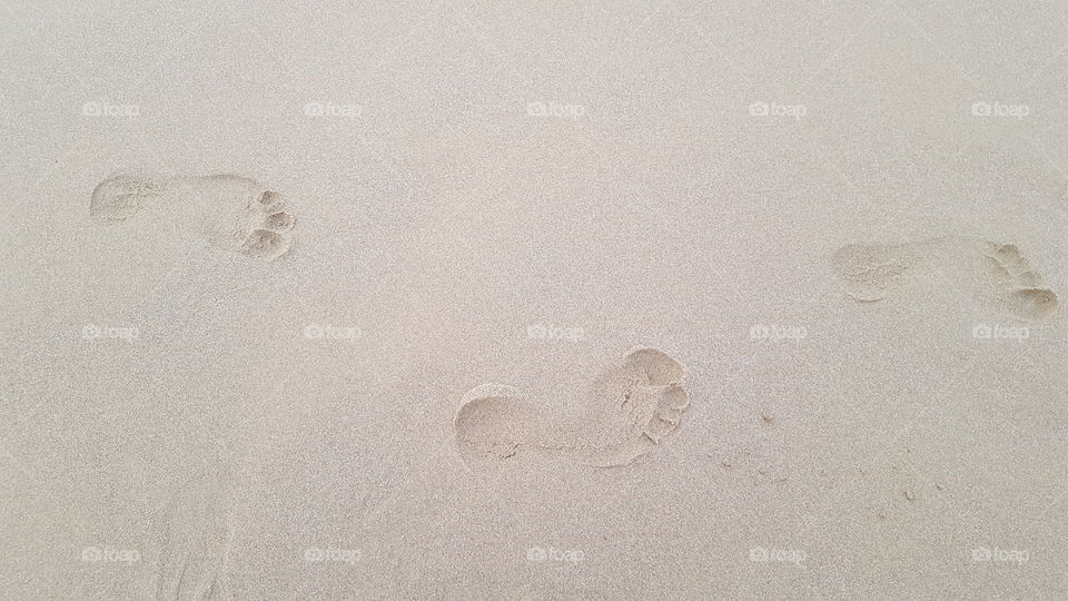 trace of feet on sand
