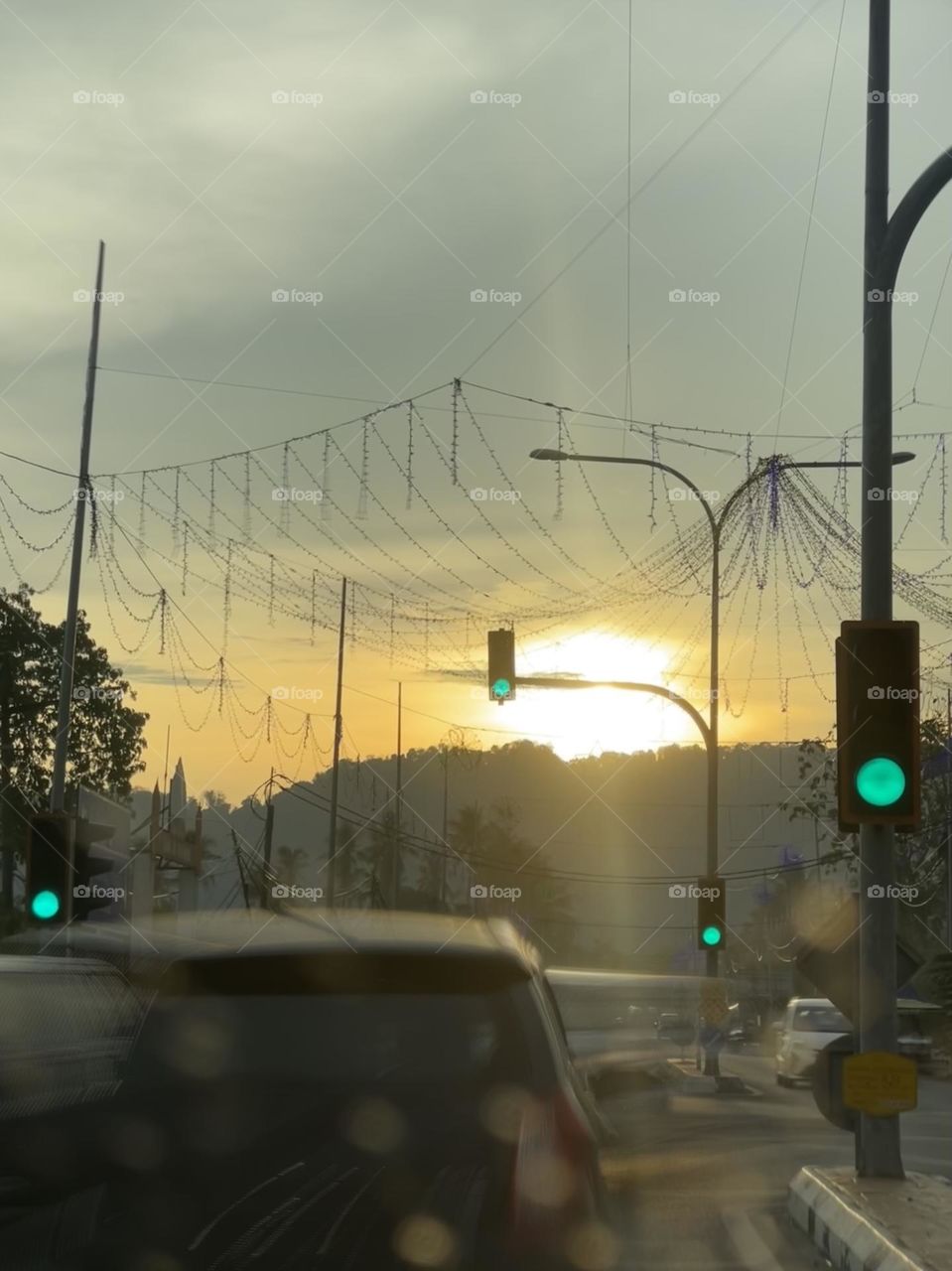 Green light on the traffic light in sunset. Car starting to speed