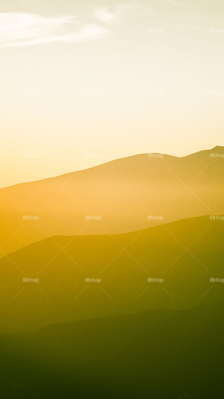 An inspiring mountain landscape. Tatry mountains in Slovakia. A beautiful wallpaper for smartphone screen. Warm summer haze, abstract gradient with perspective.