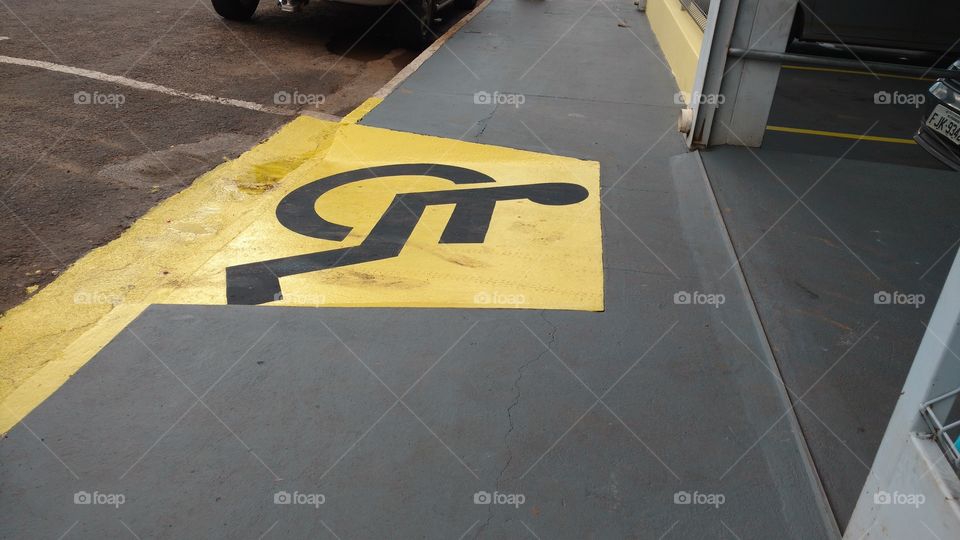 Em todos os comércios. Rampa na calçada, rebaixamento do meio fio. Com pintura amarela padrão e desenho símbolo preto de pessoa em cadeira de rodas. Lei Nacional.