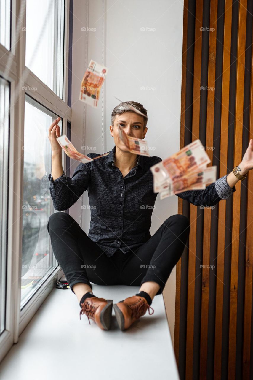 Beautiful woman sitting on the windowsill 