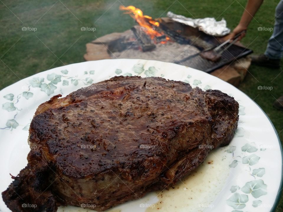 Steak grilled over an open fire pit American favorite traditional dish