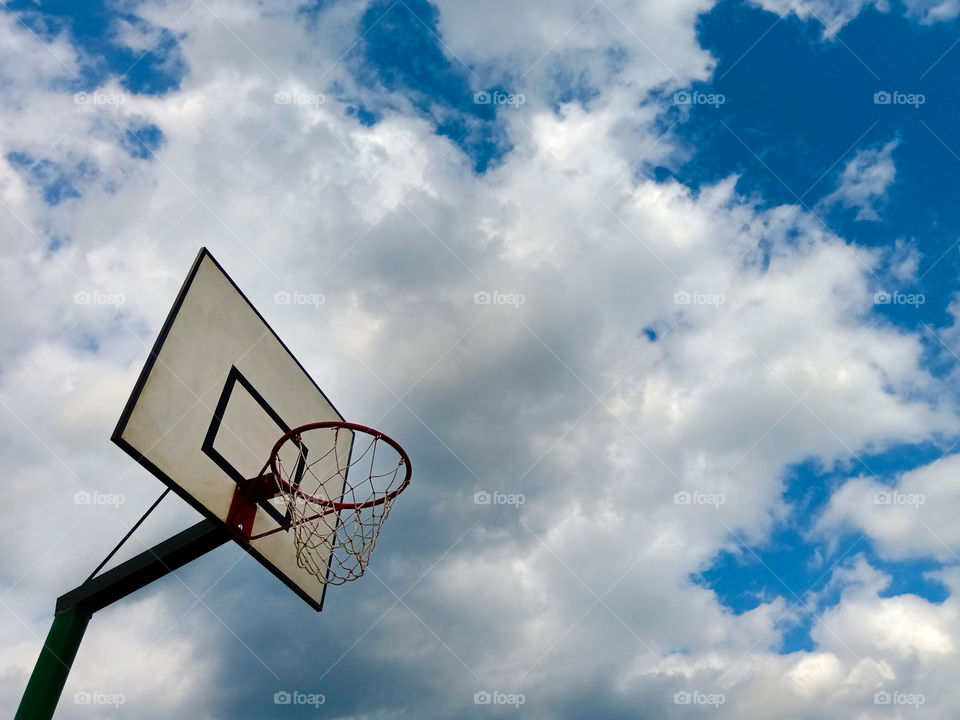 basketball hoop on a background of blue sky with clouds