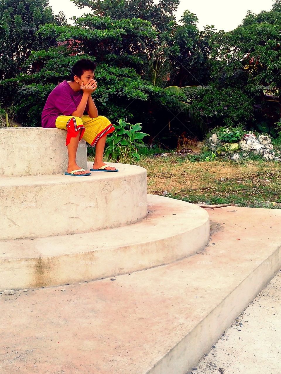 Boy sitting in a park