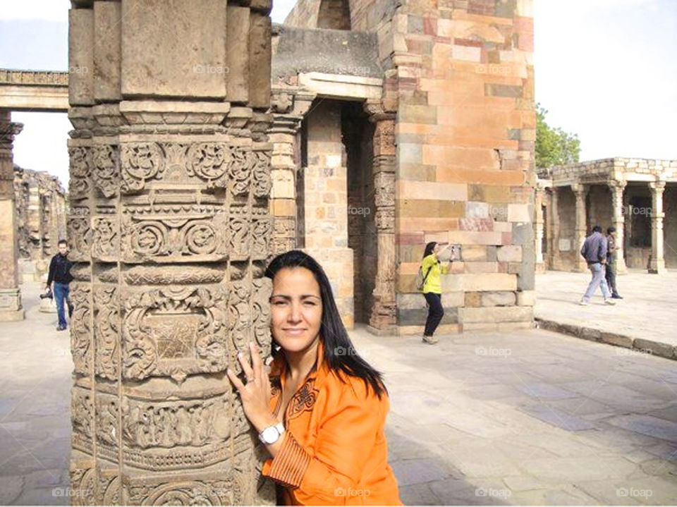 Young woman standing with historic pillar