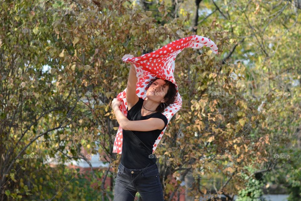 Beautiful Young Woman Dancing with Scarf Outside in Nature