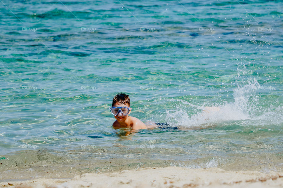 Child have fun in the water near the seashore.