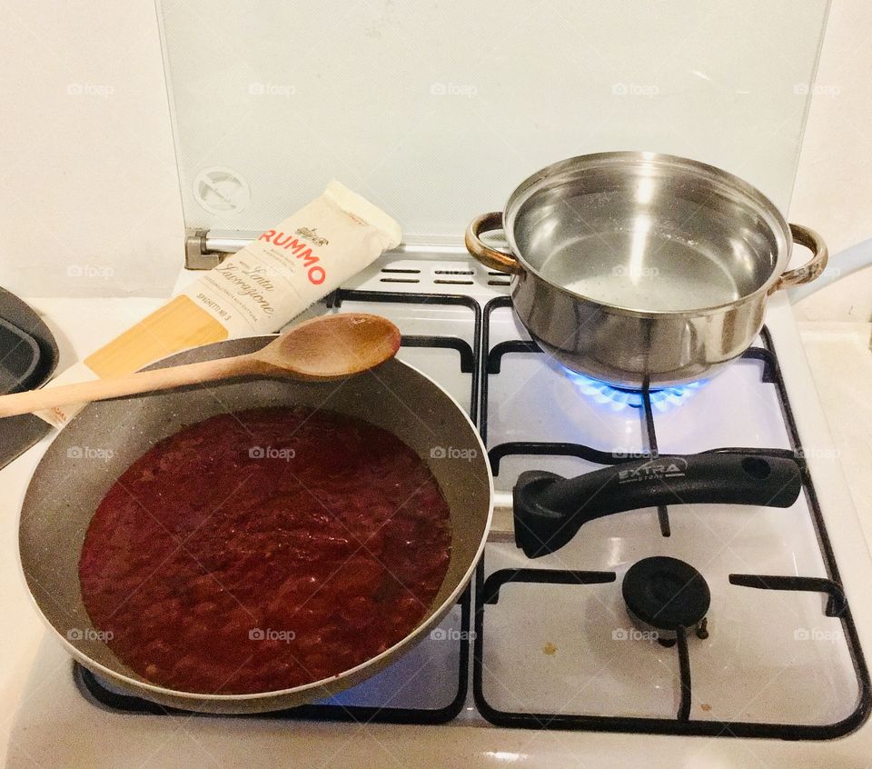 Cooking spaghetti with tomato puree for dinner.