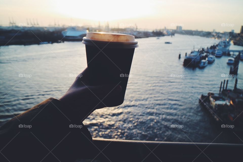 Silhouette of person holding coffee