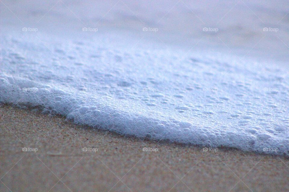 A closeup look at the foam from a crashed wave on the beach. 
