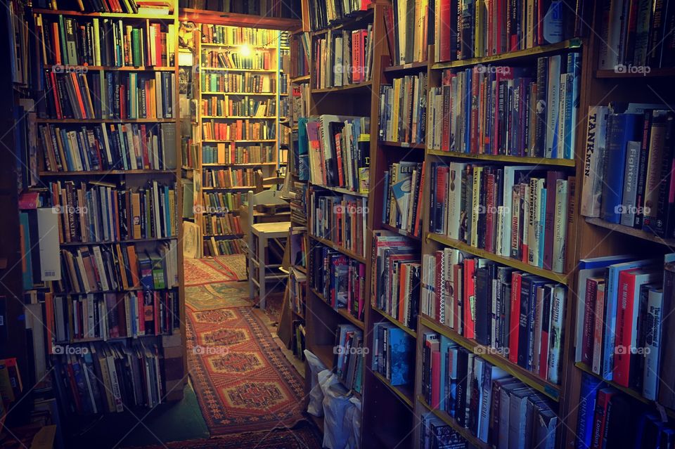 Old and new books on bookshelves in a second-hand bookshop.