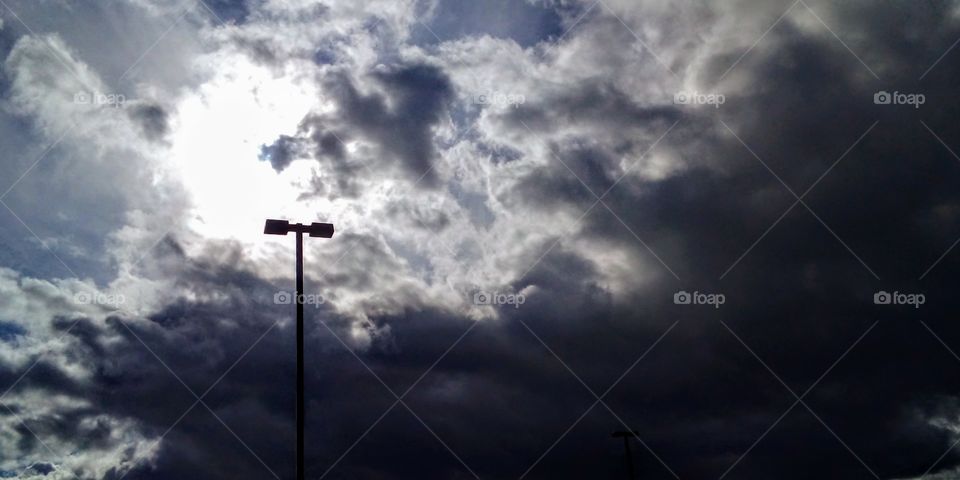 sun behind gray clouds