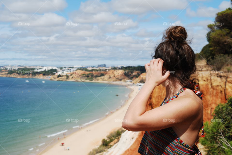 A girl overlooking a beach in Portugal.