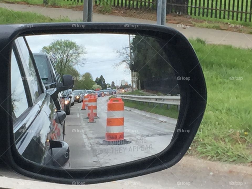 Orange construction barrels in Side view mirror