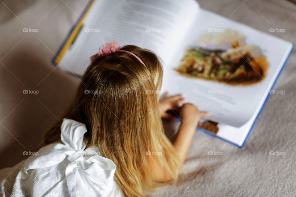 Kid reading book at home 