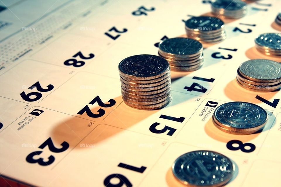Stack or pile of coins on a calendar