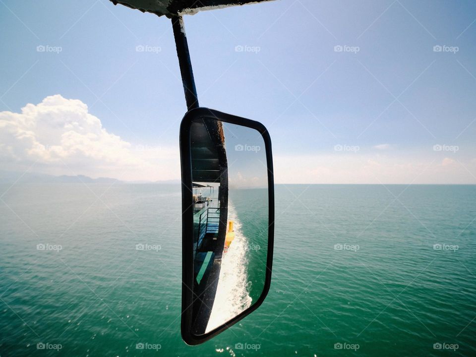 Close-up of rear view mirror on a ferry boat