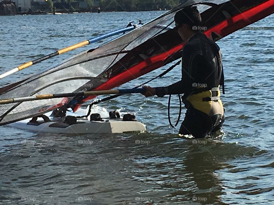 Man about to go windsurfing in water