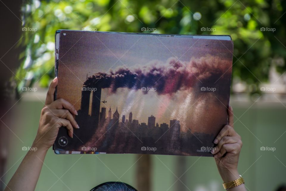 A woman holding up a photo of the 9/11 tragedy about the twin towers in Manhattan, New York 