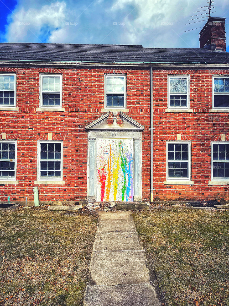 Derelict building with rainbow graffiti on its door 