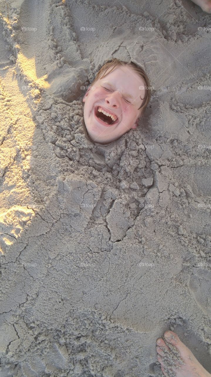 Having fun with my family makes me happy. My youngest son wanted us to bury him in the sand at Myrtle Beach.