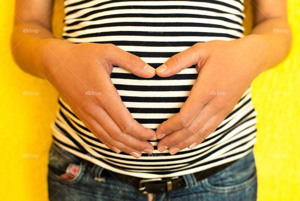 Pregnant woman making heart shape with hands