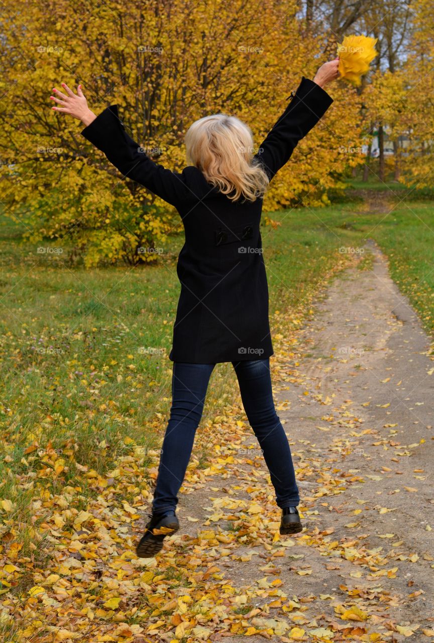 blonde girl flying autumn landscape