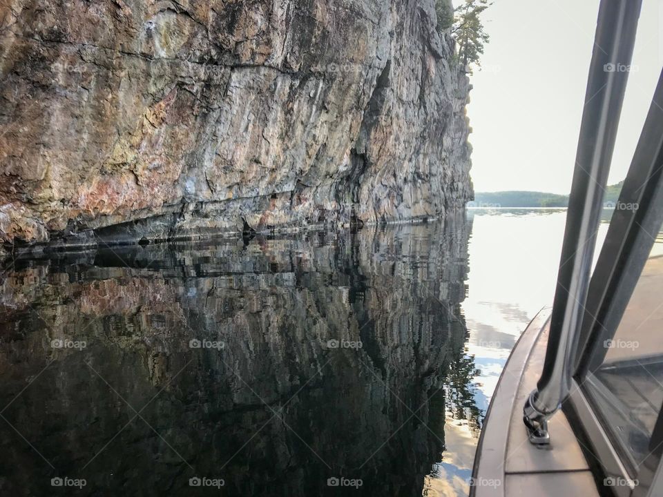 Large cliff leading into the lake with dark reflection.