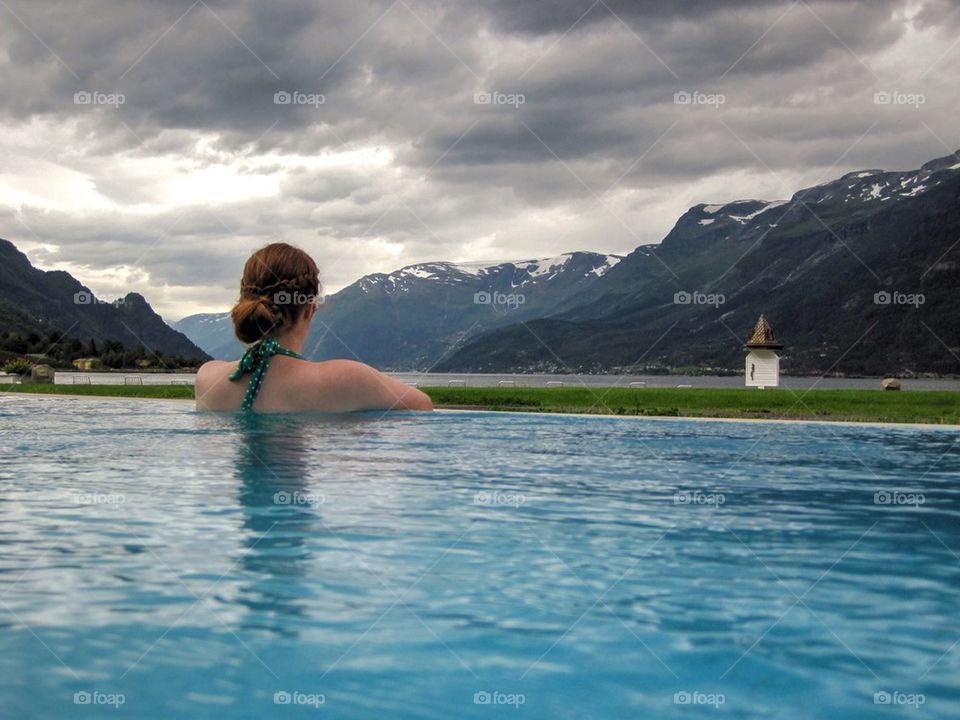 Rear view of woman in infinity pool