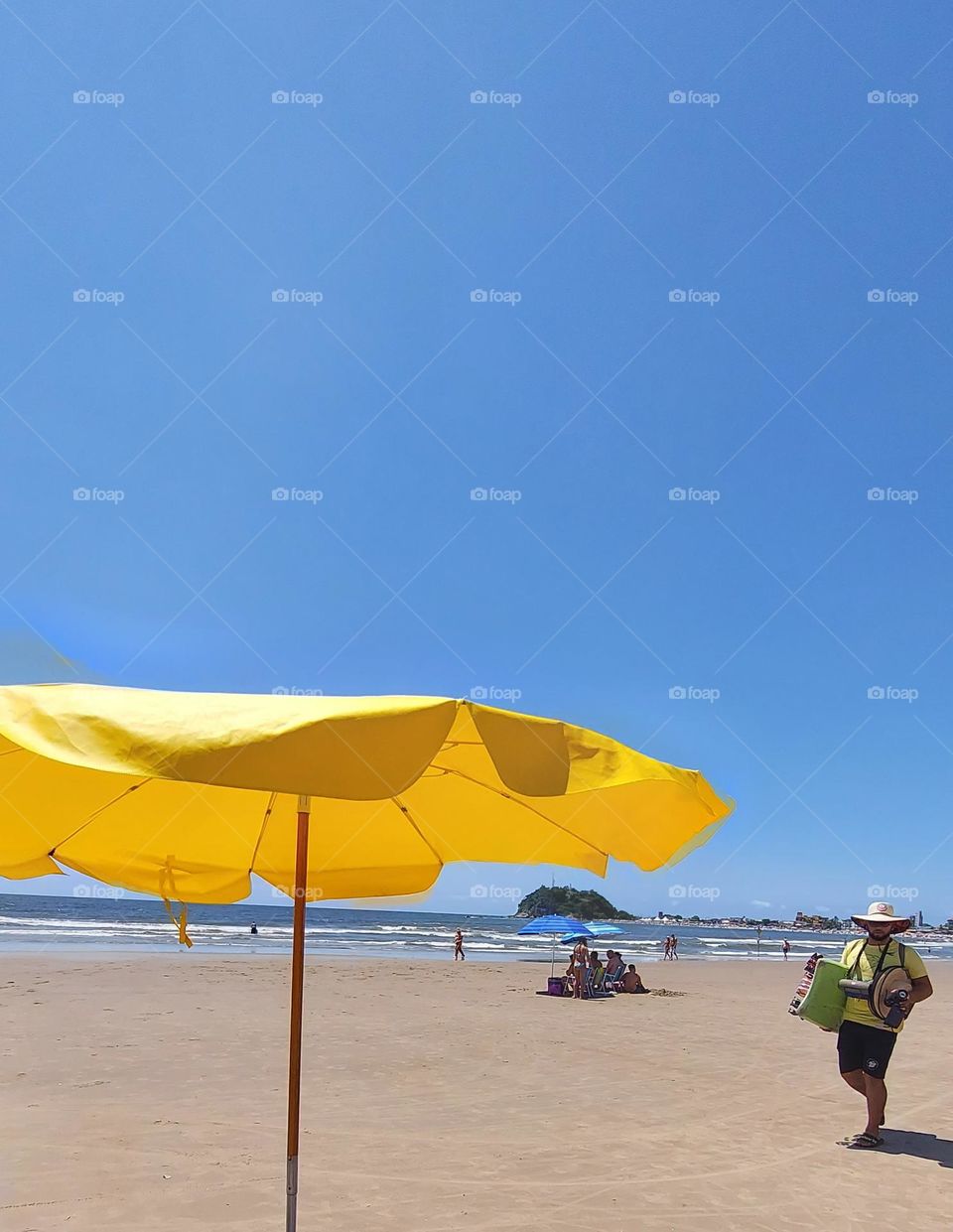 Um céu azul, um mar e um sol convidativo, mas indiferente para o vendedor que só quer vender.