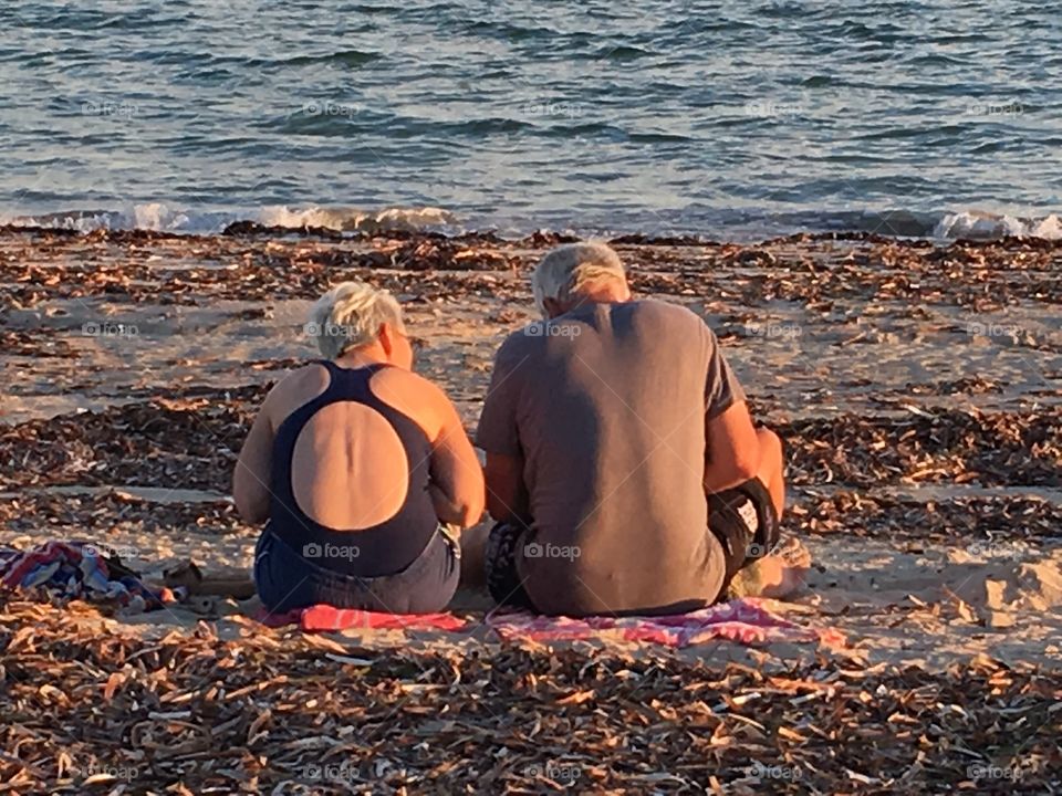 Senior
Couple sitting on beach at sunset 