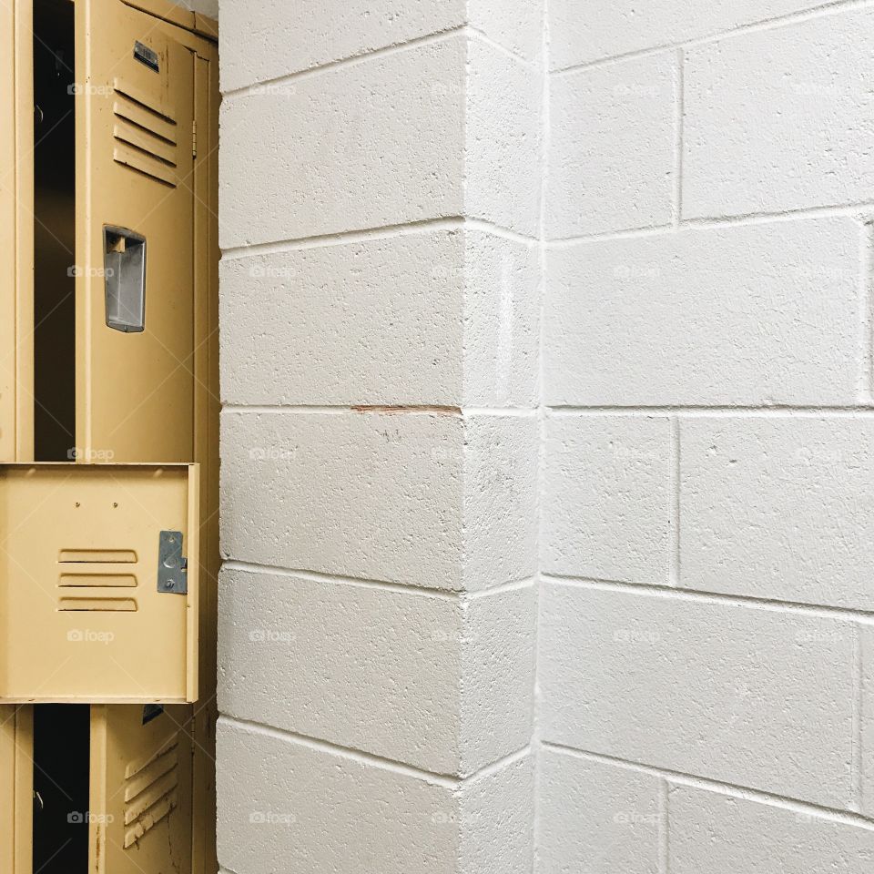 Old yellow lockers in a school locker room. 