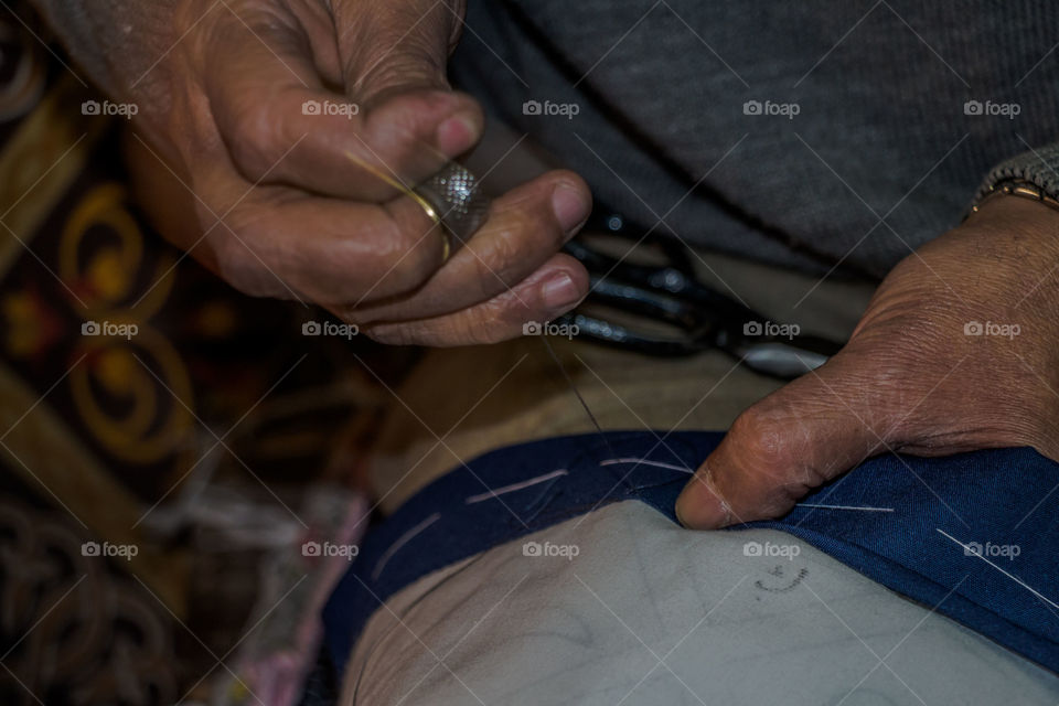 The man opens his small shop everyday and starts the sewing and embroidery of table mattresses and wall art made of textile.