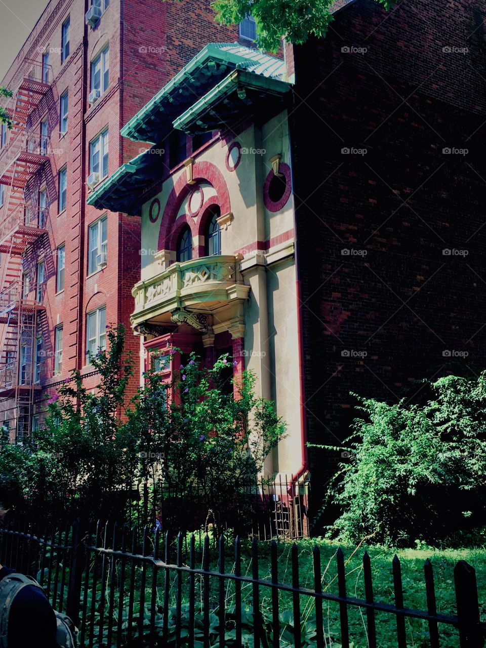 Fort Greene in Bklyn has city blocks of beautiful estates with manicured lawns, trees and bushes as well as old brownstones built in antique styles with stucco ornaments contrasting with the red facades. 2020. Hypnotic Productions