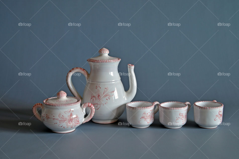 Ceramic tea set against grey background
