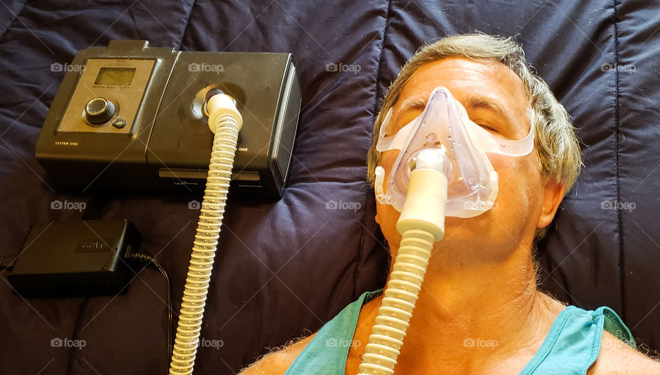 Man using CPAP machine for sleep apnea.