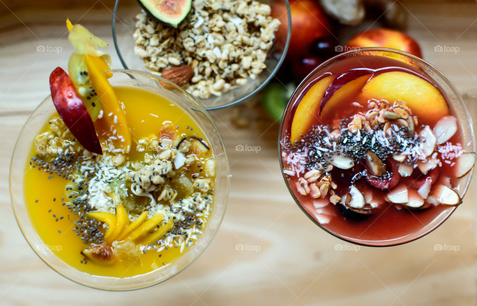 Variety of Beautiful colorful Smoothie bowls background with fruits, coconut, chia seeds, oatmeal and sunflower seeds from elevated view garnished with fresh healthy ingredients