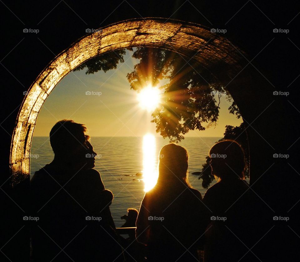 Silhouette of people under a arch at sunset