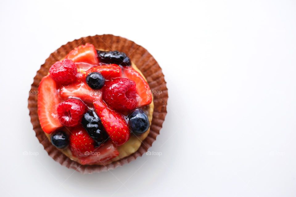 Pastries with strawberry, raspberry, blueberry covered with glaze, top view 
