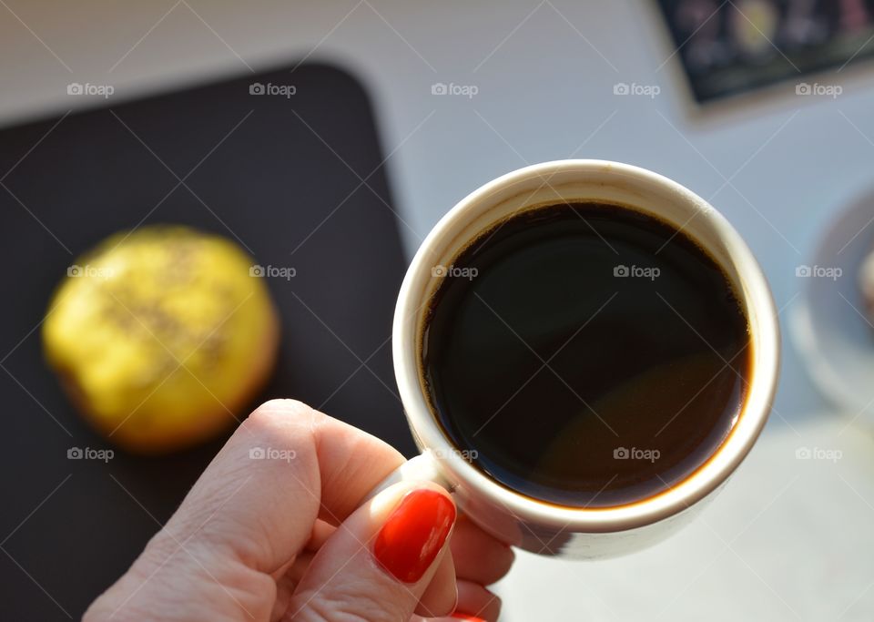 cup of coffee in the female hand in sunlight top view beautiful texture background, morning routine