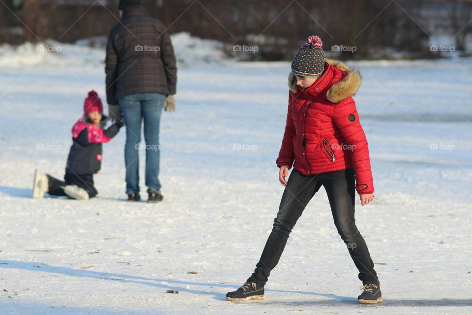 Girl with red anorak having fun on a frozen lake