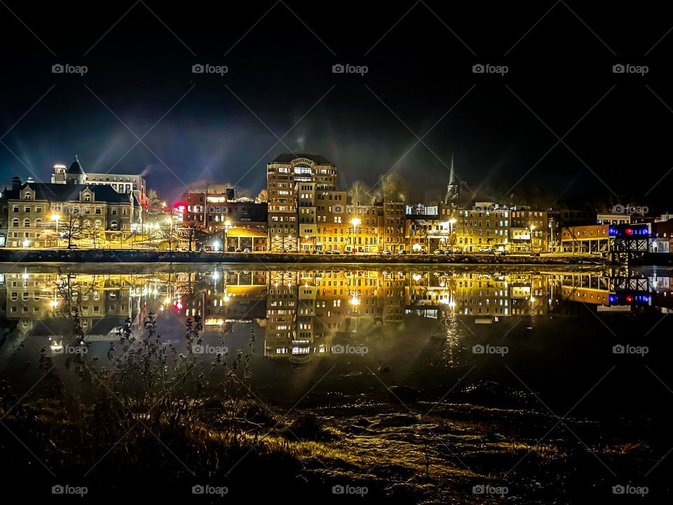 Lights of the city reflected along the river.