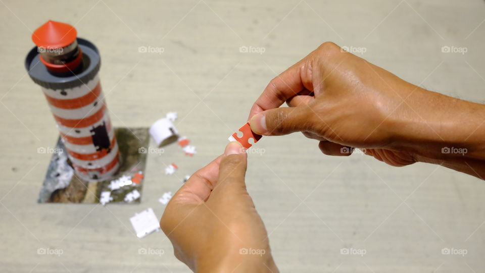 Boy putting jigsaw puzzle on lighthouse