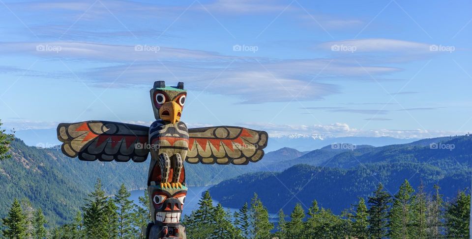 Indigenous peoples totem pole overlooking scenery in British Columbia 