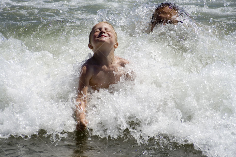 Breaking Waves. A child breaks through the waves on the beach